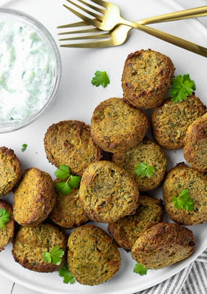 air fried falafels made with canned chickpeas on a plate with a bowl of tzatziki 