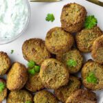 air fried falafels made with canned chickpeas on a plate with a bowl of tzatziki
